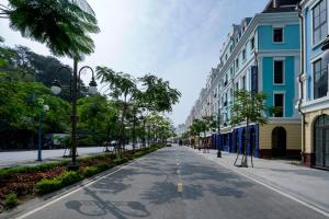 an empty city street with palm trees and buildings at 1925 Ha Long Hotel in Ha Long