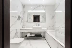 biała łazienka z umywalką i toaletą w obiekcie VICTORIA Hotel Klaipėda w Kłajpedzie