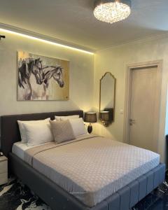 a bedroom with a bed with a painting of a horse on the wall at Aesthesis Arxontiko Luxury Rooms in Myrina