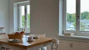 ein Esszimmer mit einem Tisch und 2 Fenstern in der Unterkunft Villa Sonneck - Wohnung 21 in Ostseebad Sellin