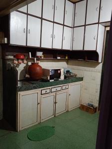 a kitchen with white cabinets and a green floor at 2BHK Flat Available for Wedding Guests, Home stay, Travelers - Mumbra in Thane