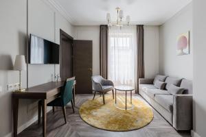 クライペダにあるVICTORIA Hotel Klaipėdaのソファとテーブルのあるリビングルーム
