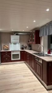 a kitchen with wooden cabinets and a stove top oven at Mountainside Lodge - Breivikeidet in Tromsø