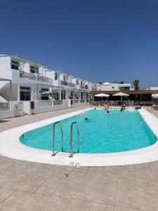 a large swimming pool with people in it at Los Gracioseras 2 Bed Apt no 218 - AC, WIFI, UK TV in Tías