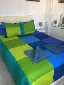 Una cama con sábanas coloridas y toallas. en Los Gracioseras 2 Bed Apt no 218 - AC, WIFI, UK TV, en Tías