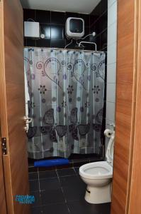 a bathroom with a toilet and a shower curtain at Proxima Centauri Hotel in Port Harcourt