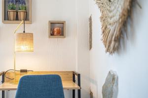 biurko z niebieskim krzesłem i lampką w obiekcie Petit nid douillet - Welc'Home w mieście Limoges