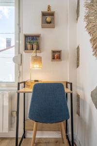a desk with a blue chair and a lamp at Petit nid douillet - Welc'Home in Limoges