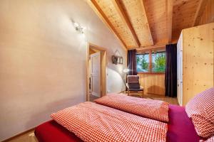 1 dormitorio con 1 cama y 1 silla en una habitación en Grushof App Paföl, en Sluderno