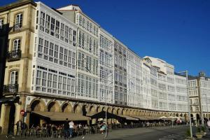 een groot gebouw waar mensen buiten zitten bij Amazing Location CORUÑA DOWNTOWN in A Coruña