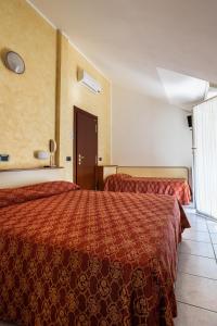 a hotel room with two beds and a window at Hotel Zanella in Cervia