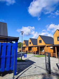 eine Gruppe von Häusern mit einem Zaun davor in der Unterkunft Zielonka Relaks in Rusinowo