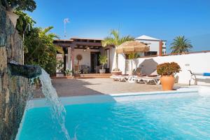 a pool with a water fountain in front of a house at Casa Golondrina in Teguise