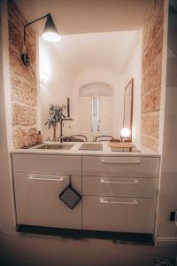 a white bathroom with a sink and a mirror at Casa 3D'Oro Palermo in Palermo