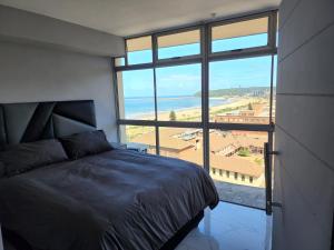 a bedroom with a bed and a view of the ocean at Sea Views at 10 South in Durban