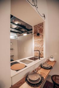 a kitchen with a sink and a counter with plates on it at Casa 3D'Oro Palermo in Palermo