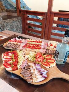 una mesa cubierta con diferentes tipos de comida y una botella de agua en Casa Daria, en Statjunea Borsa