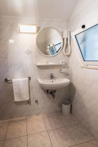 ein Bad mit einem Waschbecken und einem Spiegel in der Unterkunft Hotel Zanella in Cervia
