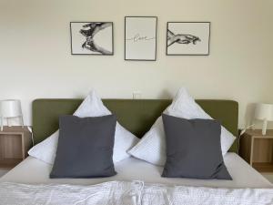 ein Schlafzimmer mit einem Bett mit vier Bildern an der Wand in der Unterkunft Ferienhaus Simon in Wadern