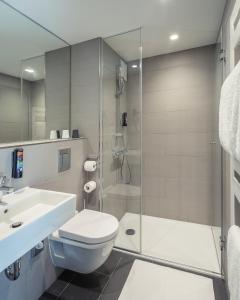 La salle de bains est pourvue d'une douche, de toilettes et d'un lavabo. dans l'établissement the niu Keg, à Hambourg