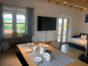 a living room with a table and a tv at Allgäu-Chalet Kaufbeuren in Kaufbeuren