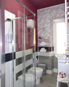 a bathroom with a toilet and a glass shower at Chloe's Rooms in Cagliari