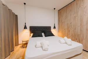um quarto com uma grande cama branca e 2 almofadas em Coverlin Apartamentos San Francisco em Málaga
