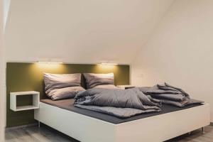 a bed with pillows on it in a room at Ferienwohnungen und Boardinghouse Heimbach in Renchen in Renchen