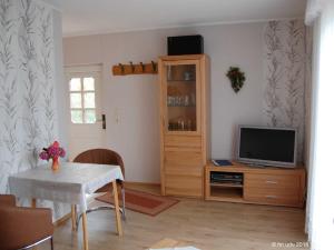 a living room with a television and a table with chairs at Ferienhaeuser Baaber Heide in Baabe