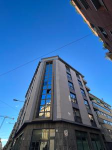 wysoki budynek ze słońcem odbijającym się w oknach w obiekcie Appartamento Moderno Torino San Salvario w Turynie