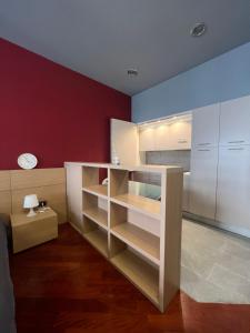 kuchnia z białymi półkami i czerwoną ścianą w obiekcie Appartamento Moderno Torino San Salvario w Turynie