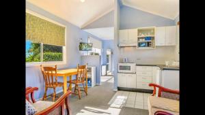 a kitchen with a table and chairs in a room at Apple Tree Cottage - Comboyne Mountain Cottages in Comboyne