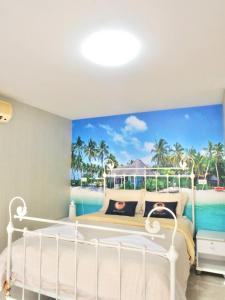 a bedroom with a mural of the ocean at RIM Chaam By RoomQuest in Cha Am