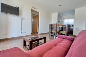 sala de estar con sofá rojo y mesa en Riviera del Sur - Apart hotel en Miramar