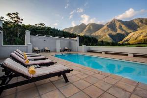 a swimming pool with a bench next to a swimming pool at Gaikou Lodge in Swellendam