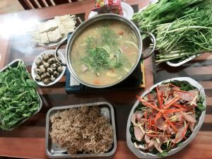 a table with a pot of soup and bowls of food at Hoa Thi hotel in Tiên Tân