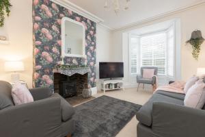 a living room with a fireplace and a tv at Charles Alexander Short Stay - Rose Cottage in Lytham St Annes