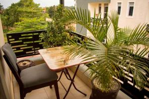 einen Tisch und Stühle auf einem Balkon mit Pflanzen in der Unterkunft THEATRE OF DREAMS HOMES in Kampala