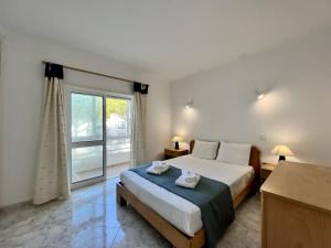 a bedroom with a bed and a large window at Albufeira Falesia Beach 4 by Homing in Albufeira