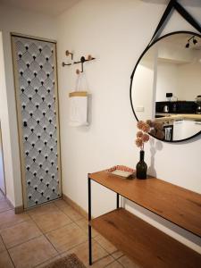 um quarto com uma mesa e um espelho na parede em Oasis de 42 m2 I Cosy I Cœur de ville I Lit 160x200 em Vaison-la-Romaine