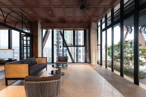 a living room with a couch and chairs and windows at Scarletz KLCC Studio Suites 4 pax Luxury Modern Style WiFi 100Mbps in Kuala Lumpur