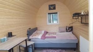 Habitación pequeña con cama en una pared de madera. en Glamping Pod im Wald mit Hund, en Nordholz