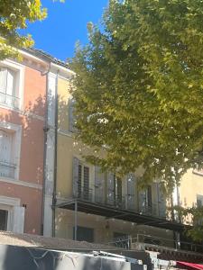 a building with a balcony on the side of it at Oasis de 42 m2 I Cosy I Cœur de ville I Lit 160x200 in Vaison-la-Romaine