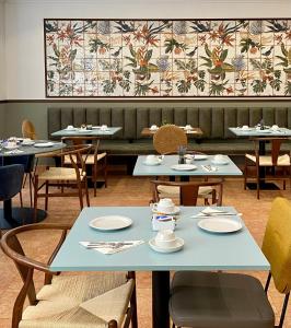 un comedor con mesas y sillas y un mural en la pared en Hôtel Casón del Tormes by HappyCulture, en Madrid