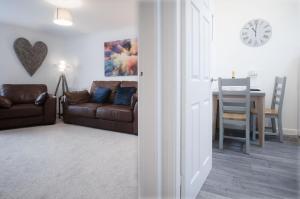 a living room with a couch and a table at Cariad Llyyad Y Dydd - 1 Bedroom Apartment - Tenby in Tenby