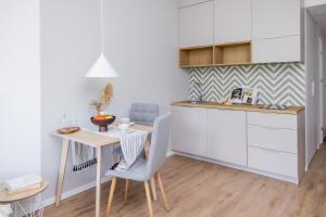 a kitchen with a desk and a table and chairs at Metro Bielany Apartments with Parking by Renters in Warsaw
