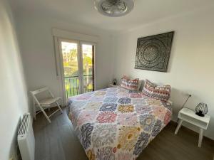 een slaapkamer met een bed met een quilt bij Apartment La Isla Bonita in Jávea