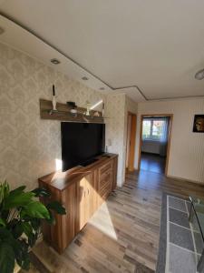 a living room with a flat screen tv on a wooden entertainment center at Schöne Wohnung mit eigenem Eingang und Parkplatz in Fulda