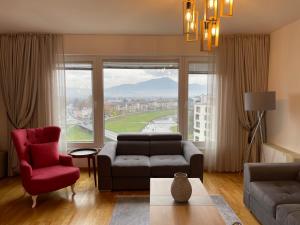 a living room with a couch and a red chair at شقة نهر اليجا in Sarajevo