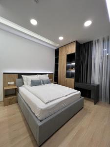 ein Schlafzimmer mit einem großen Bett in einem Zimmer in der Unterkunft OLYMPIC 84 Apartments in Sarajevo